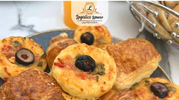 A plate of pastries with olives and vegetables.