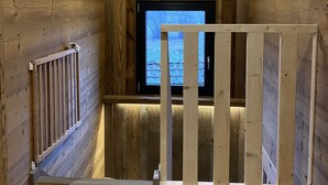 Ein Holzinnenraum mit Fenster, Heizkörper und Holzbalkon.