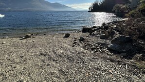 A rocky shoreline with a clear view of the water and distant mountains. - Casa Spasù: charming corner with a view 5 minutes from Cannobio, Lake Maggiore (San Bartolomeo)