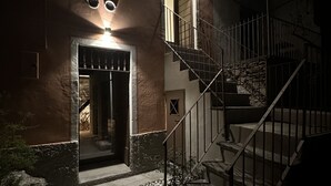 A two-story building with a staircase and a lit entrance. - Casa Spasù: charming corner with a view 5 minutes from Cannobio, Lake Maggiore (San Bartolomeo)