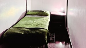 A small, narrow room with a single bed, a small table with a lamp, and a wardrobe with two doors. - Delightful little room Near Colosseum!!! (Roma)