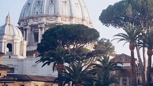 A large domed building with a smaller adjacent structure, surrounded by palm trees and other vegetation. - Delightful little room Near Colosseum!!! (Roma)