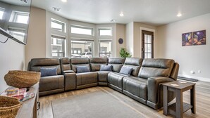 A modern living room with a sectional sofa, a wooden coffee table, and a large window providing natural light. - Stunning Mtn Views! Home 3 Mi to Dtwn Cedar City! (Cedar City)