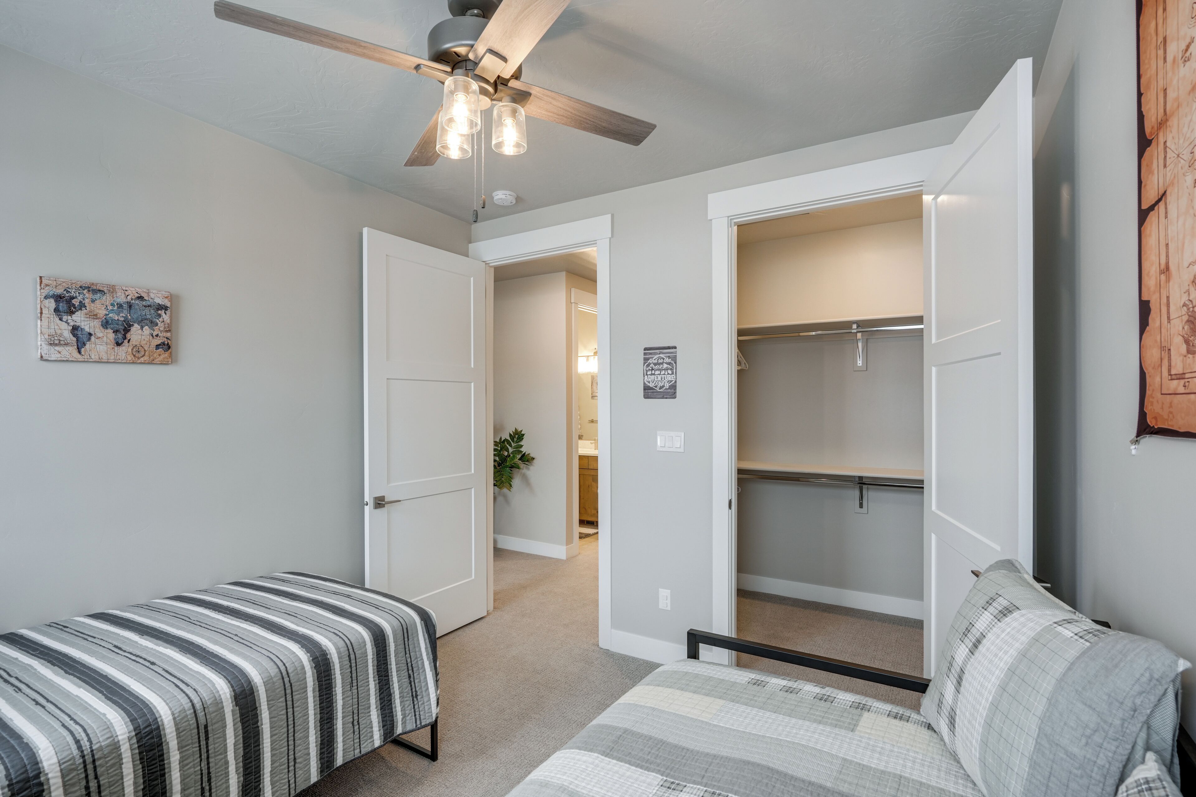 A bedroom with a bed, a wardrobe, and a ceiling fan.