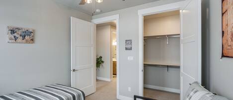A bedroom with a bed, a wardrobe, and a ceiling fan.