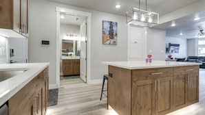 A modern kitchen with wooden cabinets, a white countertop, and a pendant light. - Stunning Mtn Views! Home 3 Mi to Dtwn Cedar City! (Cedar City)