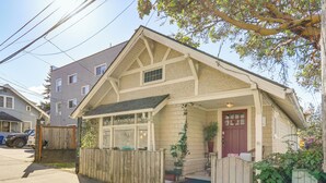 A single-story house with a front porch, a wooden fence, and a garage.