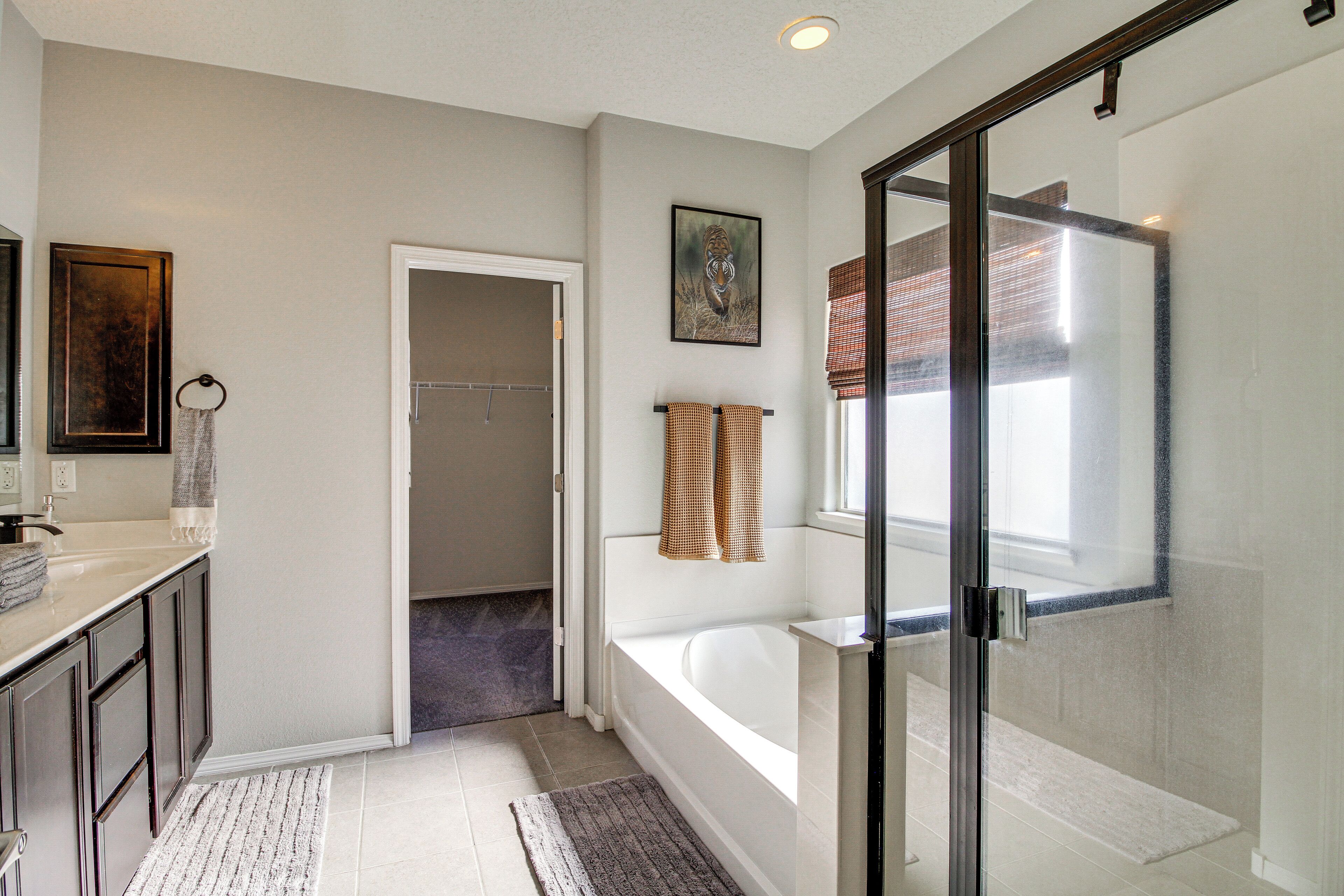 A modern bathroom with a bathtub, glass shower enclosure, and a walk-in shower.