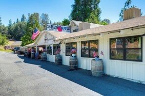 A storefront with a sign for 'The Red Apple Bakery and Fruit Stand' and American flags. - Serene Cabin Retreat Between Murphys & Arnold (Murphys)