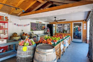 A rustic fruit stand with wooden barrels and a variety of fruits displayed. - Serene Cabin Retreat Between Murphys & Arnold (Murphys)