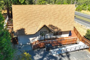 Un petit bâtiment doté d’un toit en pente, d’un porche avec des balustrades en bois et d’une porte ornée d’une guirlande.