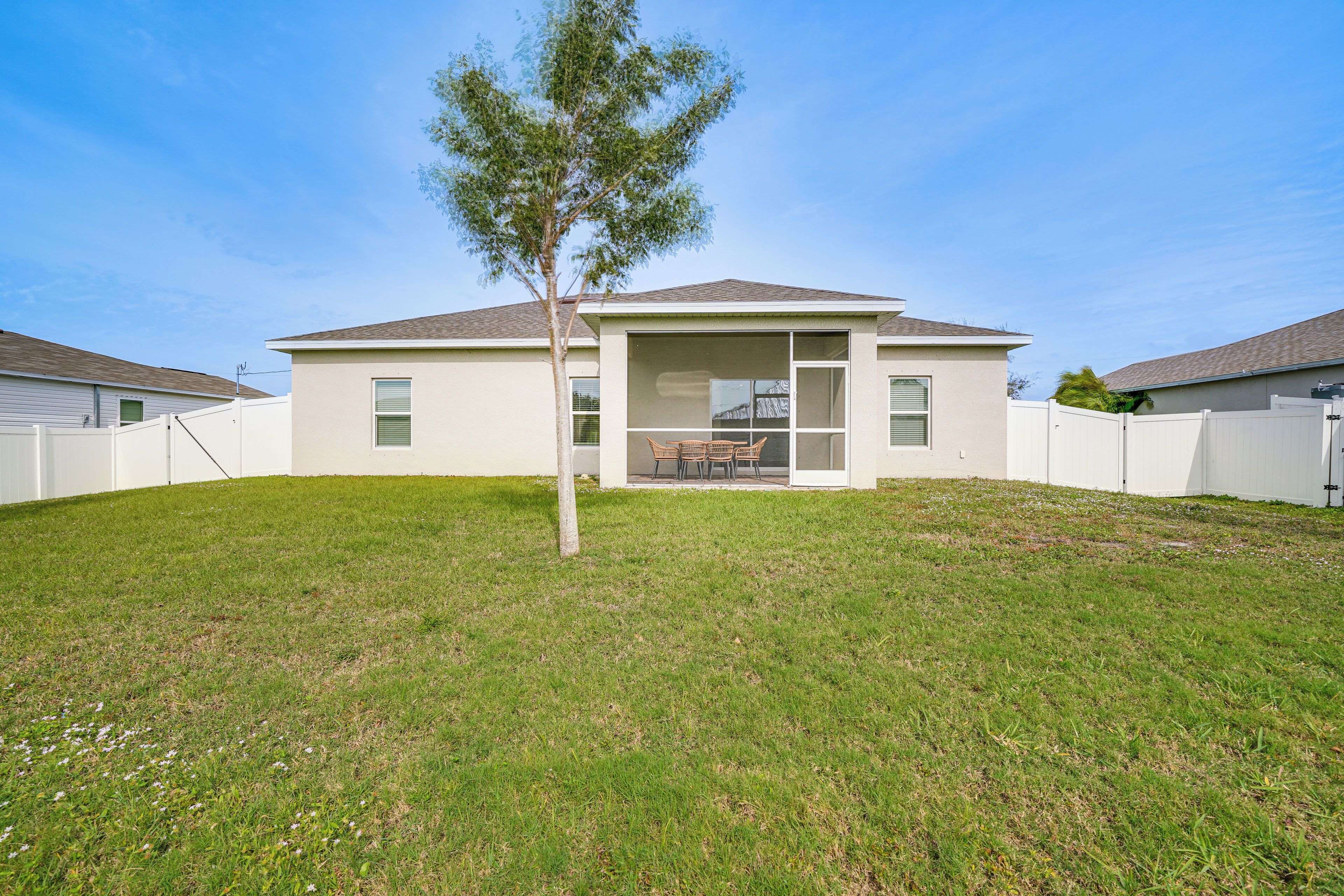 A modern two-story house with a covered patio and a small lawn.