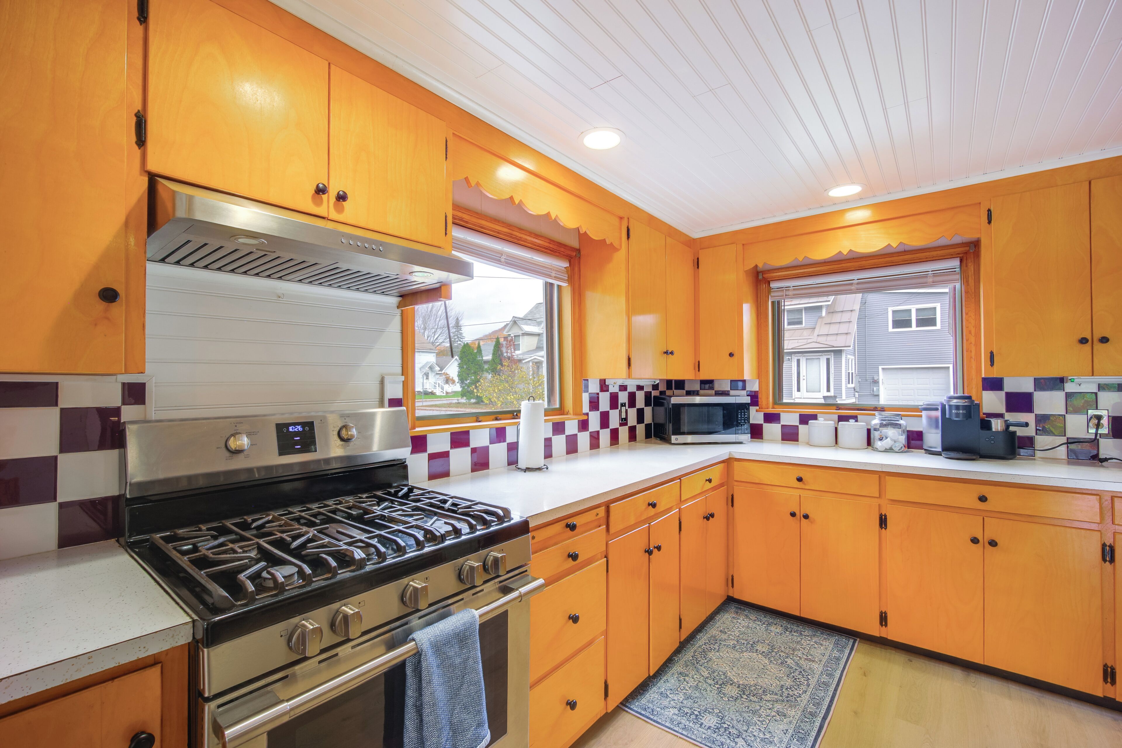 Une cuisine avec des meubles en bois, une cuisinière en acier inoxydable et un four à micro-ondes.