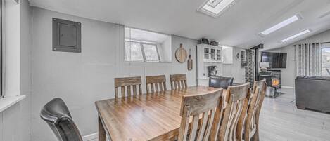 A dining area with a wooden table and chairs, a built-in cabinet, and a fireplace.