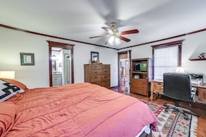 A bedroom with a large bed, wooden dresser, desk, and a ceiling fan. - Clarksville Home w/ Porch & Fishing Pond Access! (Clarksville)