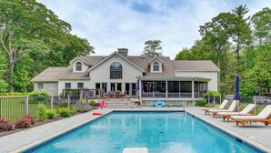 A swimming pool with lounge chairs and a house in the background. - Monterey Home w/ Hot Tub, Pool & Game Room! (Monterey)