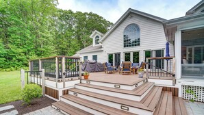 A two-story house with a deck, outdoor furniture, and a covered area. - Monterey Home w/ Hot Tub, Pool & Game Room! (Monterey)