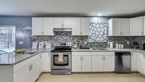 A modern kitchen with white cabinets, a stainless steel stove, and a dishwasher. - Pennsylvania Home w/ Hot Tub: 7 Mi to Kalahari! (Tobyhanna)