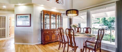 Un coin repas avec une table en bois, des chaises et un lustre.