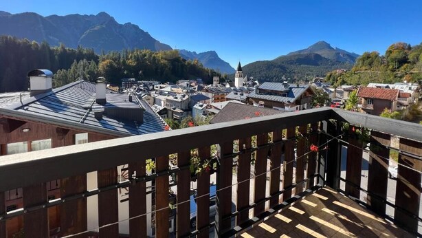 Un balcón con vistas a un pueblo y montañas.