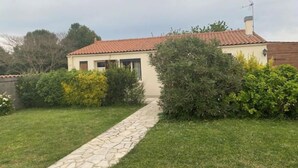 Una casa con techo de tejas, un sendero de piedra y un césped bien cuidado.