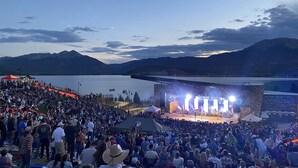A large outdoor concert stage with a crowd in front.