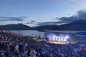A large outdoor concert stage with a crowd in front.