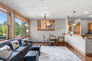 A modern living room with a sofa, ottoman, and dining area with chairs and a table. - Charming Mountain Retreat in Keystone, Colorado (Keystone)