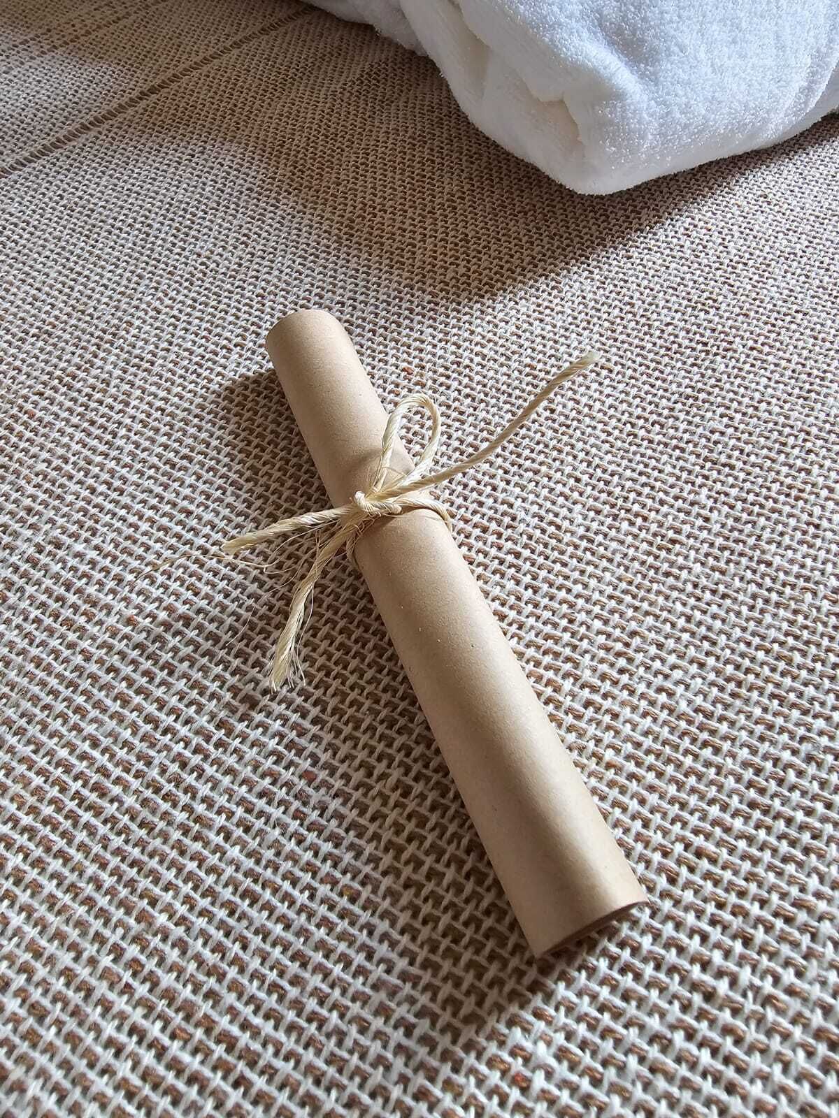 A rolled-up piece of paper tied with a string on a textured surface.