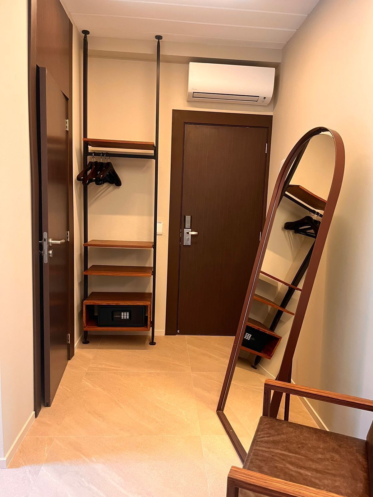 Quarto com guarda-roupa, espelho e estante.