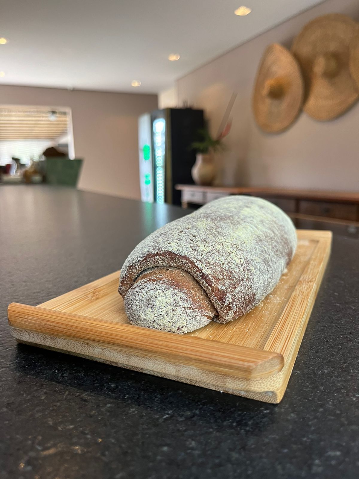 Una hogaza de pan sobre una tabla de madera en una cocina.