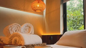 A hotel room with a neatly made bed, a tray with two cups, and a hanging light fixture. - Pousada Yamandu (São Sebastião)