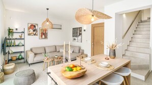Una sala de estar moderna con un sofá, una mesa de comedor y una escalera.