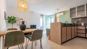 Une cuisine moderne avec des meubles en bois, un coin repas comprenant une table et des chaises, et un luminaire suspendu.
