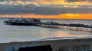 A pier extending into calm waters with a sunset in the background. - Seaview Regency Apartment With Private Parking (Brighton)