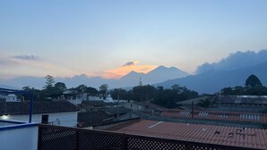 A residential area with houses, a mountain in the background, and a clear sky. - Hotel Teresas Bistro Antigua (Antigua Guatemala)