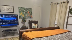 A bedroom with a bed, a TV, a chair, and a rug. - Spacious retreat on beautiful Lake June. Lake Placid, FL (Lake Placid)