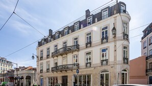 Un immeuble à plusieurs étages, de style architectural classique, doté de balcons et de grandes fenêtres.