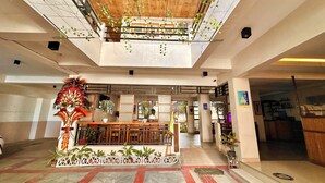 A spacious lobby with a high ceiling, wooden beams, and a central seating area. - Papierus Pensionne (Kalibo)