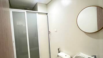 Une salle de bain avec des toilettes, un lavabo et un miroir.