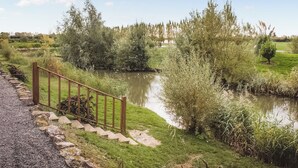 Un sentier menant à un plan d’eau, bordé d’une clôture en bois et agrémenté de marches.