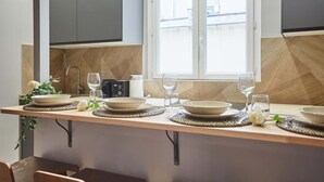 Une cuisine moderne dotée d’un îlot central, de meubles de rangement intégrés et d’une fenêtre laissant entrer la lumière naturelle.