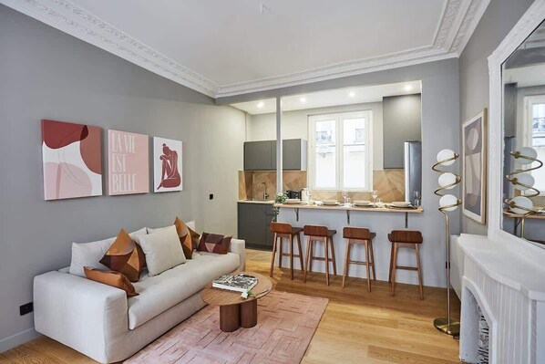 A modern living room with a sofa, coffee table, and artwork on the wall.