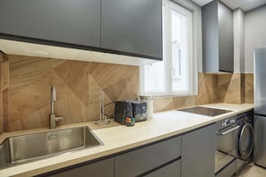 A modern kitchen with a stainless steel sink, a toaster, and a built-in oven.