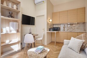 Um espaço compacto com cozinha compacta, área de refeições e espaço para sentar.