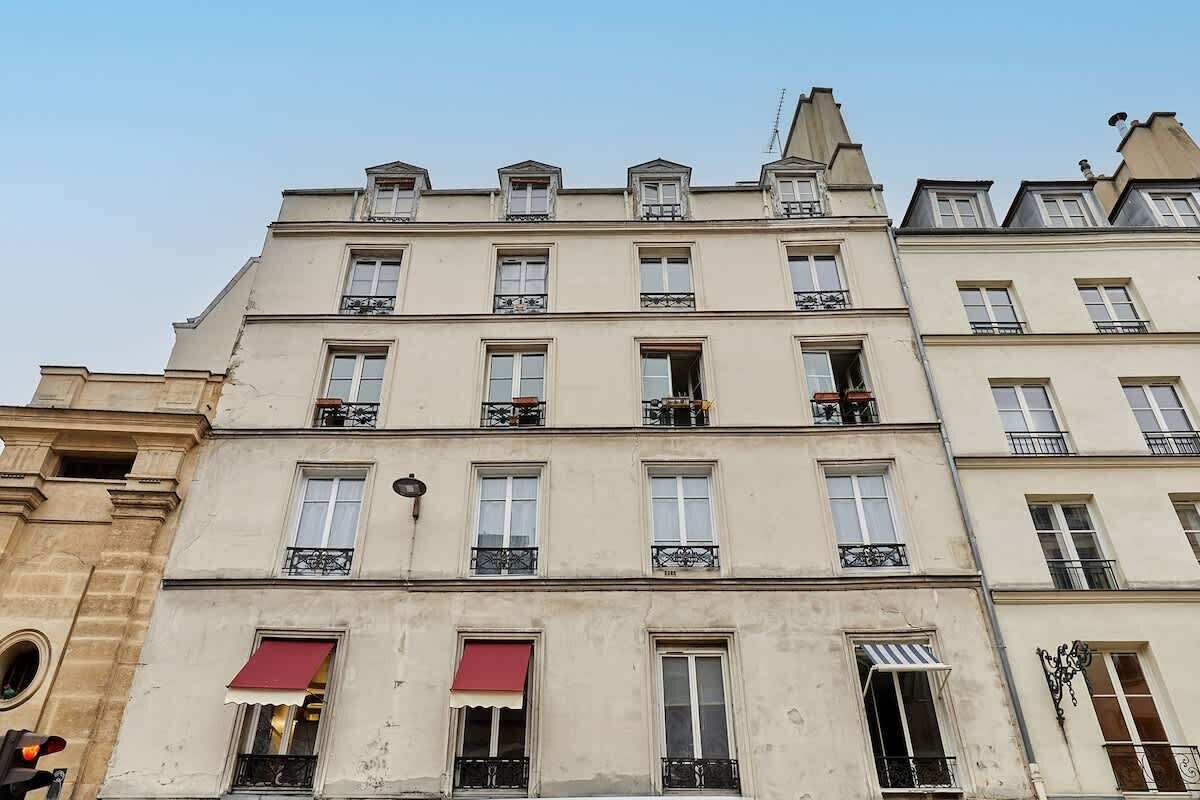 En byggnad med flera våningar i en klassisk arkitektonisk stil, med balkonger och fönster försedda med markiser.