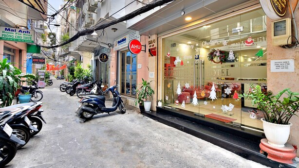A hotel entrance with a glass door, decorated with Christmas ornaments, and a sign indicating the hotel is open.