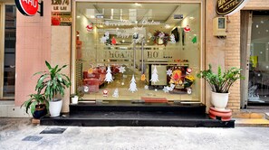 A hotel entrance with a Christmas-themed window display, including snowflakes, Christmas trees, and Santa Claus decorations. - S79 Residences Charisse (Ho Chi Minh City)