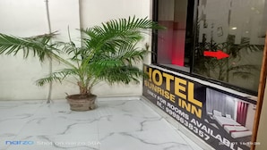 Ein Hotel Eingang mit einem Schild für 'Sunrise Inn' und einem Blumentopf.