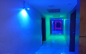 A hallway with colorful LED lighting. - Hotel Sunrise Inn (Ahmedabad)